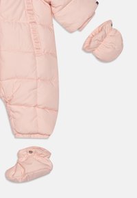 Roze gevoerde sneeuwpak met ribbels aan de mouwen, inclusief bijpassende wanten en schoentjes. Glad textuur met gev quilt details door het hele pak.