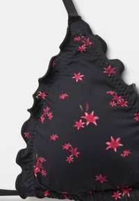 Schwarzer Bikini-Oberteil mit pinkem Blumenmuster, gewellten Kanten, verstellbaren Trägern und glatter Stofftextur. Nahaufnahme des Cup-Details.