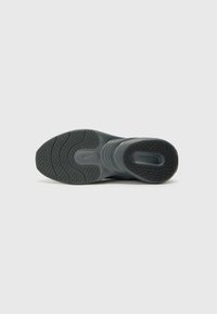 Sola de ténis Nike, apresentando um design ondulado com borracha texturizada, predominantemente preta com acentos cinzentos, proporcionando tração e suporte.