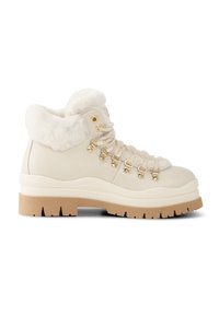 Kremowe buty trekkingowe z fakturowaną skórzaną cholewką, kołnierzem wyłożonym futrem, złotymi elementami ozdobnymi i grubą, ryflowaną brązową podeszwą.