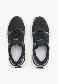 Zwarte sportieve schoenen met een bovenwerk van mesh en synthetisch materiaal, een dikke witte zool, een gevoerde tong en gestructureerde veters. Voorzien van reflecterende accenten.