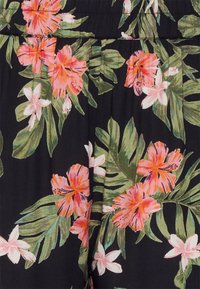 Černá látka s živými růžovými a bílými květinovými vzory. Obsahuje velké hibisky a menší květiny s zelenými listy po celé ploše.