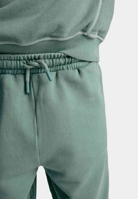 Blød, mintgrøn sweatshirt og joggersæt med ribbet halsudskæring, justerbar snor i taljen og tekstureret stof.