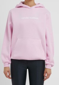 Felpa con cappuccio rosa in tessuto morbido, con tasca frontale e la scritta "GOOD KARMA" in bianco, con cappuccio regolabile con cordoncino.