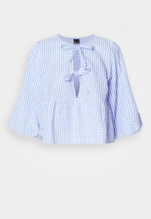 Zila un balta Gingham blūze ar garām zvana piedurknēm, kakla saitē, un savāktu pepluma apakšdaļu. Viegls audums, ikdienišķs dizains.