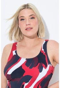 Punainen, tummansininen ja valkoinen kuvioitu uimapukun yläosa, jossa on pyöreä pääntie ja leveät hihnat, valmistettu sileästä ja venyvästä kankaasta.