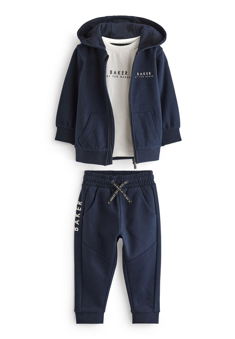 Conjunto de chándal azul marino que incluye una sudadera con cremallera y pantalones con cintura elástica. La sudadera tiene un estampado de logotipo en blanco; los pantalones incluyen bolsillos laterales.