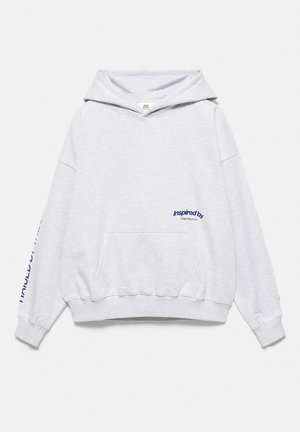 Sweat à capuche gris clair avec poche avant, manches longues et texte bleu "Inspired by Urban Rhythms" sur la poitrine et la manche, posé à plat sur fond blanc.