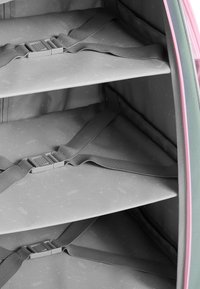 Grijze binnenkant van een zachte tas met drie rekken, vastgemaakt met grijze banden en een plastic gesp; voorzien van een roze accent langs de rand.