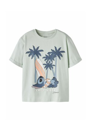 Chemise vert clair à manches courtes avec un koala bleu dessin animé allongé sous des palmiers, une planche de surf rayée, le texte « CHILL VIBES » et la signature « Hawaii ».