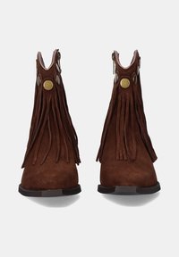 Botas de tobillo de ante marrón con detalles de flecos, cremalleras laterales y acentos de latón. Presenta una puntera redondeada y una suela plana para mayor estabilidad.
