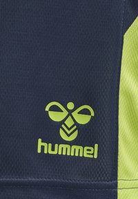 Marinblå sporttyg med strukturerade ränder och en ljusgul logotyp med en distinkt design. Höger sida är i solid gul mesh.