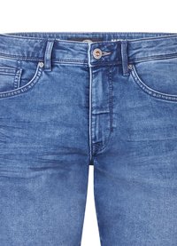 Jeans in denim blu con un design classico a cinque tasche, chiusura con zip e bottone. Presentano un aspetto sbiadito con effetti di scolorimento e sfumature sottili.