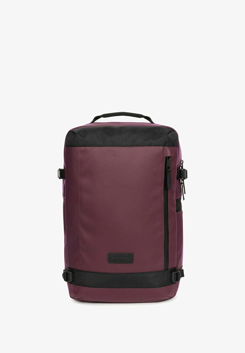 Sac à dos rectangulaire bordeaux avec bordure noire, poignée supérieure, boucles latérales, poche avant zippée et logo Eastpak sur le panneau avant.