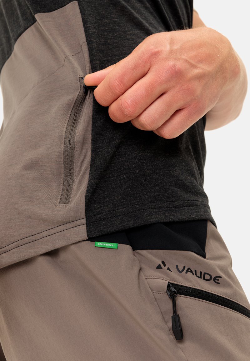 Männer-Outdoormidlayer mit einem schwarz-grauen Design, leichtem Stoff, Reißverschlusstasche und einem grünen "GreenShape"-Tag.