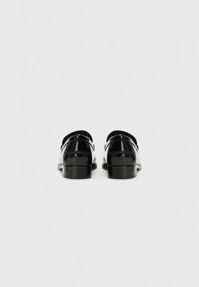 Schwarze Lacklederschuhe mit abgerundeten Zehen, niedrigen Blockabsätzen und einer glatten, glänzenden Oberfläche. Verfügt über subtile Nahtdetails entlang der Nähte.