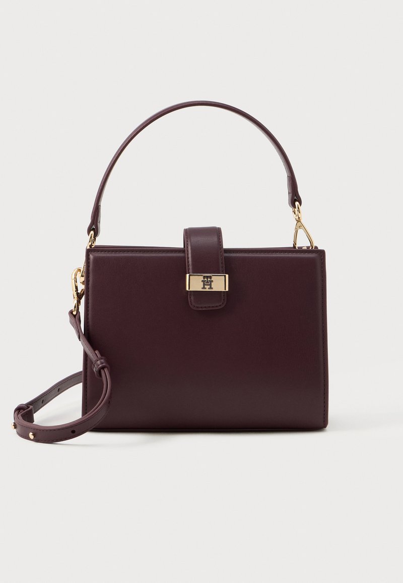 Borsetta in pelle bordeaux con forma strutturata, ferramenta dorata, manico superiore e tracolla removibile. Caratterizzata da una chiusura a gancio e un accento con logo.