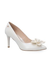 White leather high heel pump with a pointed toe, adorned with a flower accent featuring a pearl, and a light beige interior.