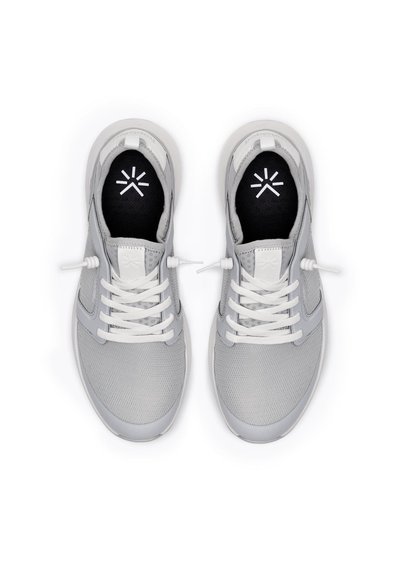 Scarpe da ginnastica grigio chiaro con tomaia in rete, lacci bianchi e soletta nera con logo bianco. Forma della punta rotonda, design minimalista.