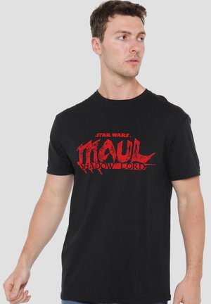 Man wearing black T-shirt with red "Star Wars Maul Shadow Lord" graphic text, looking to his right against a plain light background.