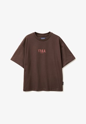 Brown short-sleeve T-shirt with round neck, oversized fit, and text "Y'ALL JEANS WEST" printed in faded pink on the chest.