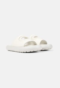 Vita sandaler i vitt med öppen tå-design, mjukt övre material och präglad yta. Den tjocka, flexibla sulan har en strukturerad sula.