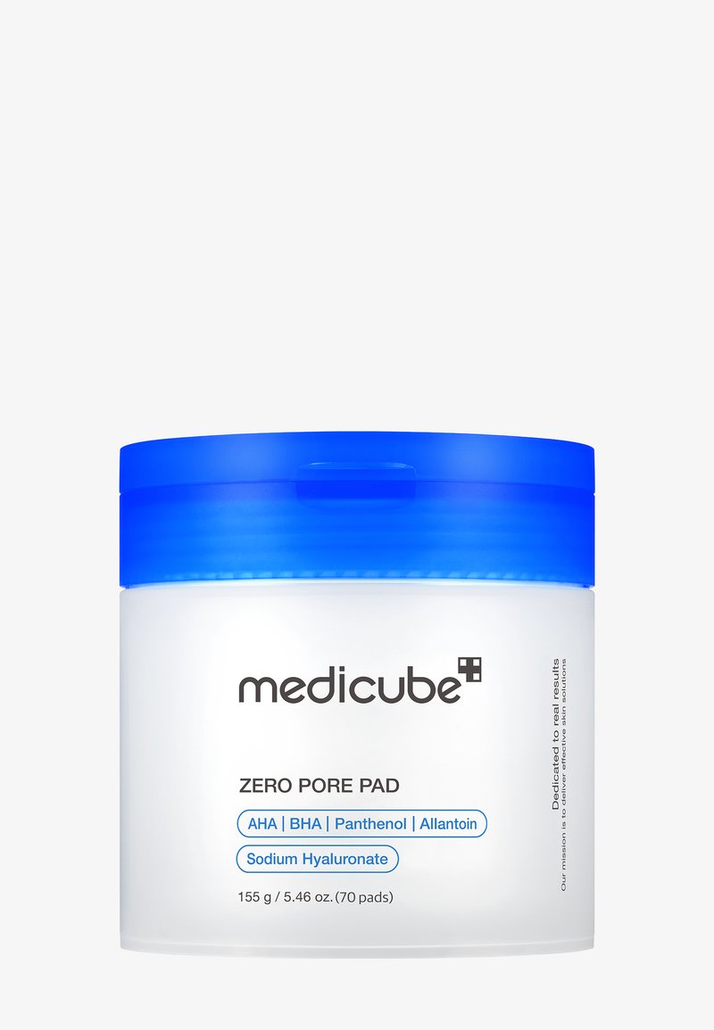 Rund, genomskinlig behållare med blått lock; märkt "Medicube Zero Pore Pad." Innehåller 155 g med 70 pads; framhäver nyckelingredienser som AHA och BHA.