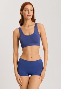 Blå sömlös crop top och hög midja shorts tillverkade av mjukt, elastiskt tyg; har en rund halsringning och breda axelband.