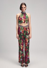 Färggängd crop top och vida byxor i ett set med livfulla blommönster och geometriska mönster, tillverkade av lättviktsmaterial med en figursydd midja.