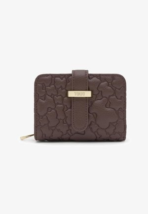 Portafoglio in pelle marrone con forme di orso impresse, targhetta dorata "TOUS" sulla cinghia frontale e chiusura con cerniera sul lato.