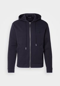 Sweat à capuche zippé noir avec poches avant, capuche à cordon de serrage et logo brodé discret sur la poitrine gauche.