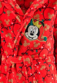 Accappatoio rosso in peluche con motivi di Topolino marroni e verdi. Presenta un patch di Minnie Mouse con una corona, una cintura e una morbida texture.
