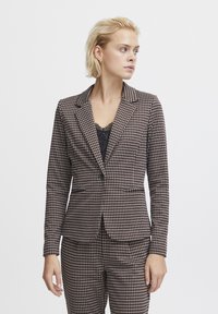 Brown checkered blazer made of textured fabric, featuring a single button closure, lapels, and two front pockets. Paired with coordinating pants.