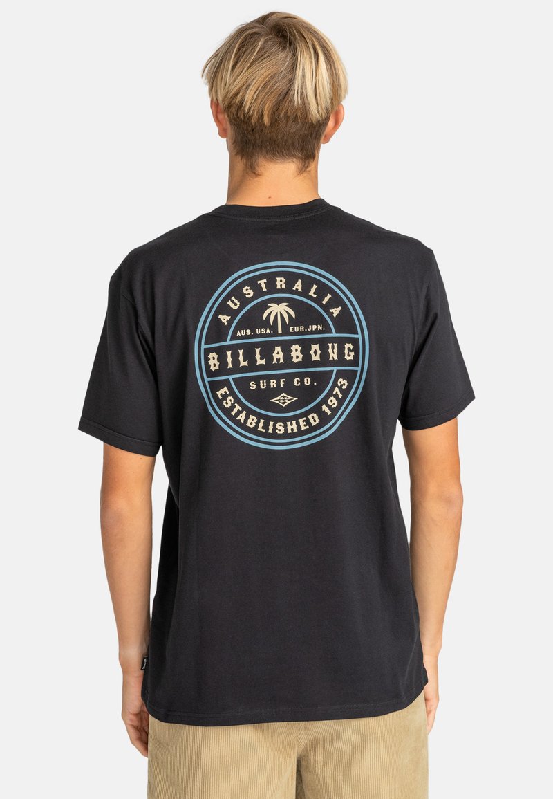 Black cotton T-shirt featuring a circular graphic with "Billabong Surf Co." and a palm tree design, accented with blue and cream colors.