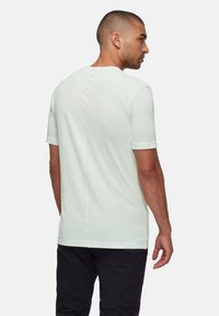 Mintgrön kortärmad T-shirt med rundad halsringning, med rak skärning och subtil sömdetaljering på baksidan.