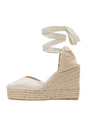 Espadrilla a zeppa beige con tacco a piattaforma intrecciato e lacci alla caviglia in tessuto coordinato su sfondo bianco.