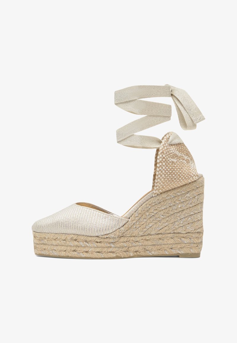 Espadrille compensée beige avec talon plateforme tissé et liens à nouer à la cheville en tissu assorti sur fond blanc.