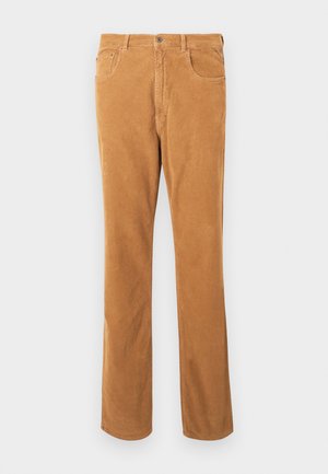 Pantaloni in velluto a coste color marrone chiaro con design classico a cinque tasche e chiusura con bottone, esposti in piano su sfondo bianco.