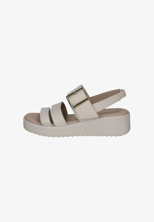 Witte platformsandalen met drie brede banden en een grote metalen gesp. Getextureerd voetbed en geribbeld zool voor grip.