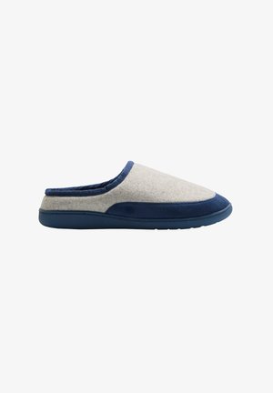 Pantufla gris de felpa con una suela sintética azul marino, que presenta un ribete azul y un diseño de punta redondeada. Sin parte trasera, estilo sencillo para poner y quitar.