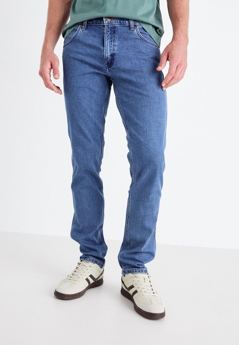 Vaqueros de mezclilla azul claro con un corte recto, que cuentan con un diseño clásico de cinco bolsillos y acentos de costura a lo largo de las costuras.