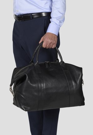 Black leather duffel bag with dual handles, zip closure, and side accents. Smooth texture and prominent stitching details.