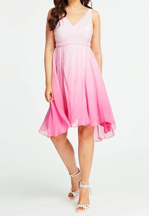 Rosa ombreklänning med V-ringning och figursydd överdel. Flödande kjol i knälängd; genomskinligt tyg med mjuk textur. Kombinerad med vita sandaler med remmar.