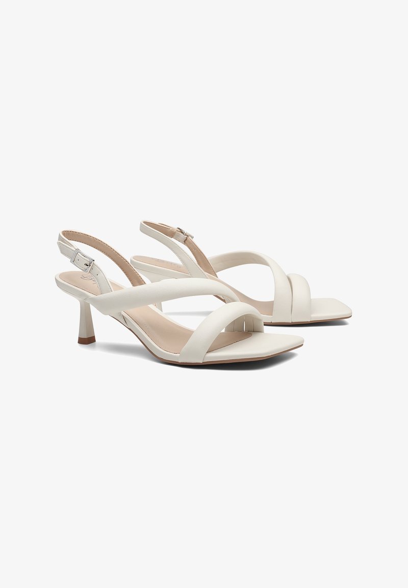 Sandales slingback blanches pour femme avec bout carré, deux larges brides, boucle réglable et petit talon kitten sur fond blanc.
