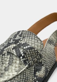 Slip-on παπούτσι με μοτίβο δέρματος φιδιού σε γκρι και μαύρο, με στρογγυλεμένη μύτη, δύο διακοσμητικές λουρίδες και ταμπά δερμάτινο πάτο.