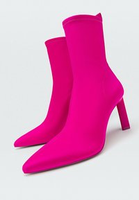 Hot pink ankle boots with a pointed toe, made of smooth fabric. Features a stiletto heel and seamless design with visible stitching accents.