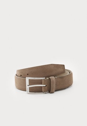 Suede-Gürtel in Hellbraun mit glatter Textur und silberner Metall-Schnalle. Verfügt über fünf Löcher und genähte Kanten für Langlebigkeit.