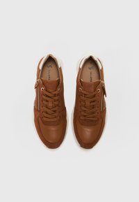 Brown leather sneakers with a textured surface, featuring front lacing, a side zipper, and a contrasting white sole. Size 38 displayed inside.