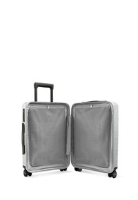 Hard-shell spinner suitcase in silver, featuring a retractable handle, four wheels, and a mesh interior with compartments for organization.
