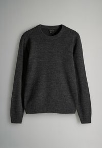 Ciemnoszary sweter z długim rękawem typu crewneck, wykonany z wełny, wiszący na jasnoszarym tle, rozmiar średni, z prążkowanymi mankietami i dołem.